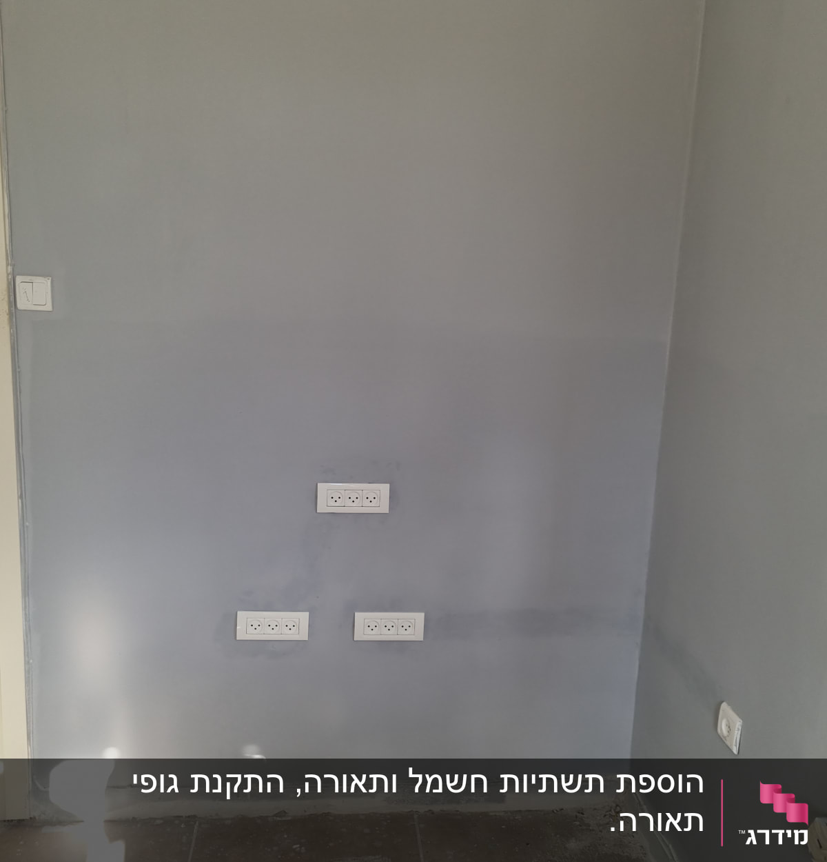 שקעים ומתגים על קיר אפור בחדר